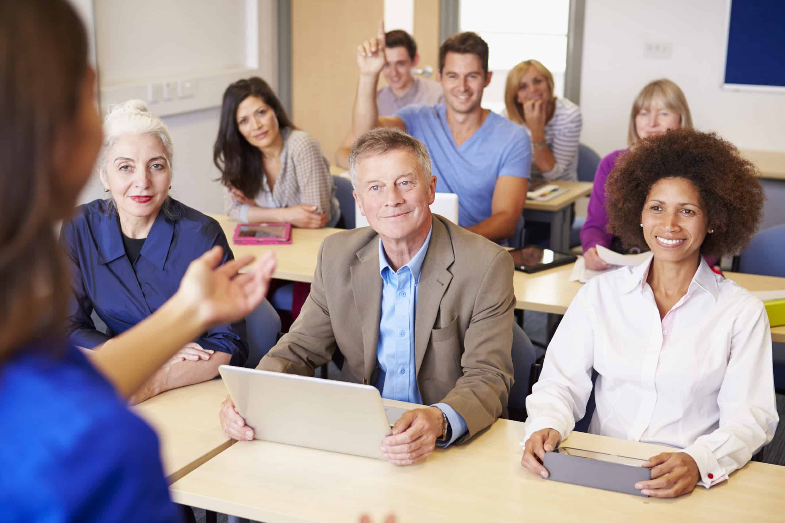 Mature Students In Further Education Class With Teacher
