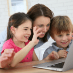 Mutter nutzt mit ihren zwei Kindern den Laptop für eine Videokonferenz. © goodluz - stock.adobe.com