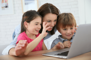 Mutter nutzt mit ihren zwei Kindern den Laptop für eine Videokonferenz. © goodluz - stock.adobe.com
