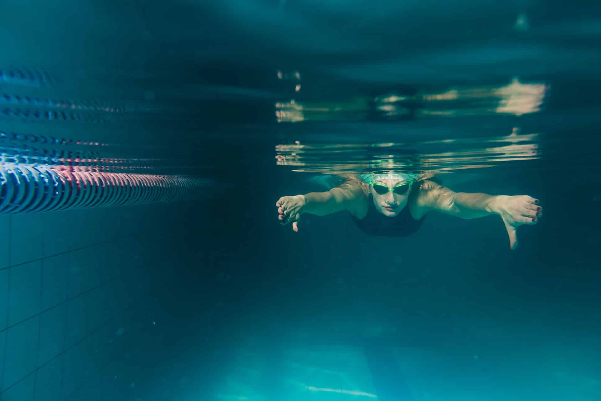 Bahnenschwimmerin unter Wasser in Aktion. Bild von magnific.com