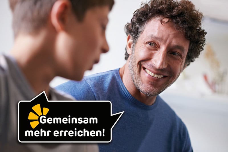 lachender Vater mit Sohn in Gespräch vertieft © PeopleImages - iStockphoto.com