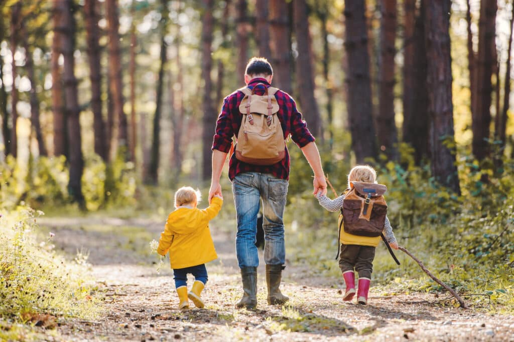 Mann geht mit kleinen Kindern im Wald wandern. © Halfpoint - stock.adobe.com